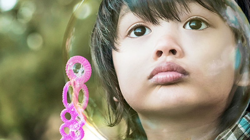 Photo of a boy seen through a large bubble